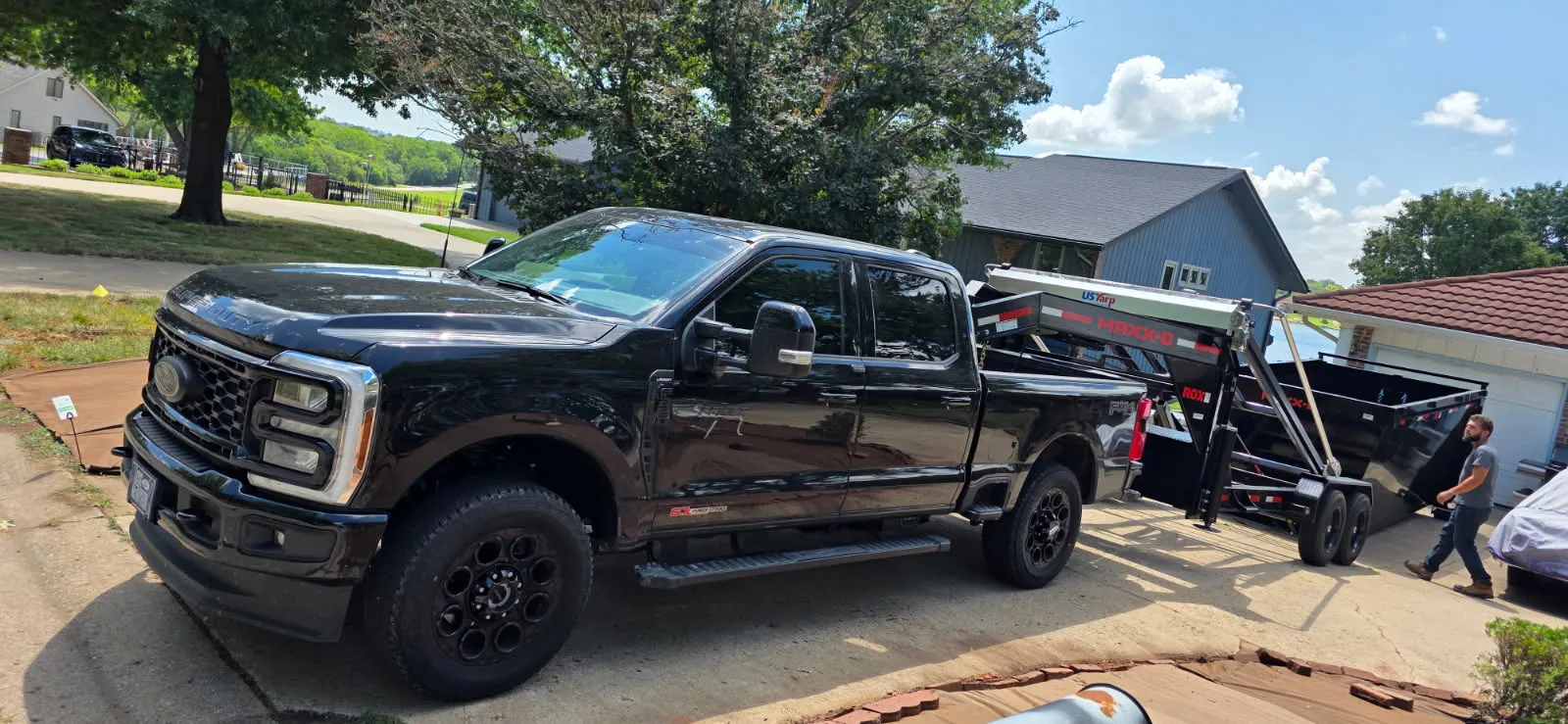Black pickup backing a trailer into a driveway for a move