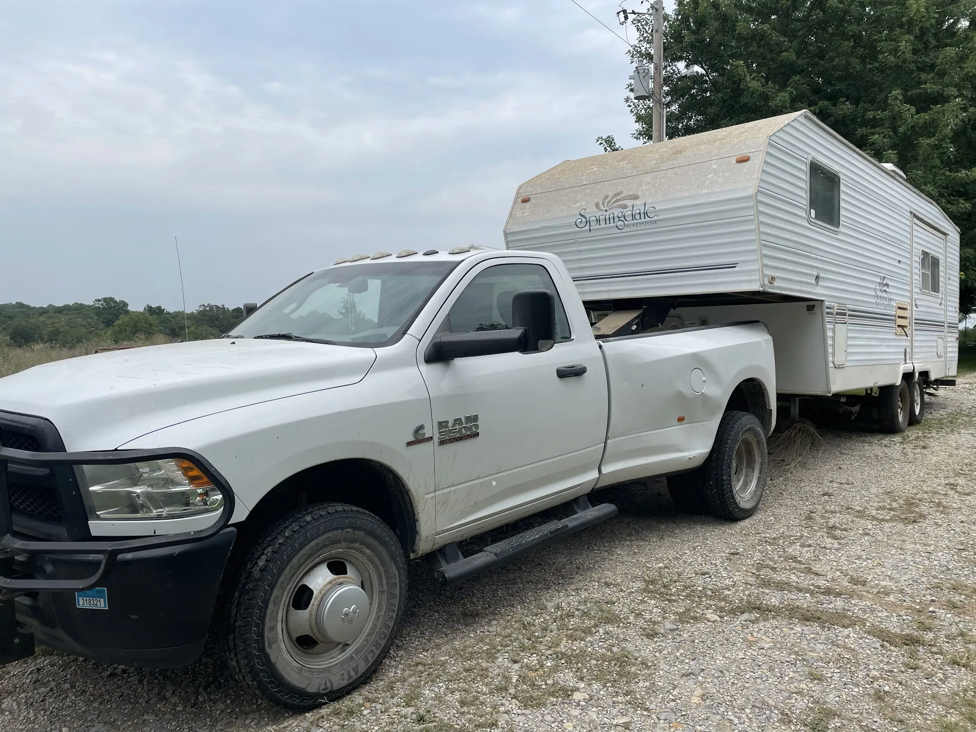 Pickup towing away an old fifth-wheel camper