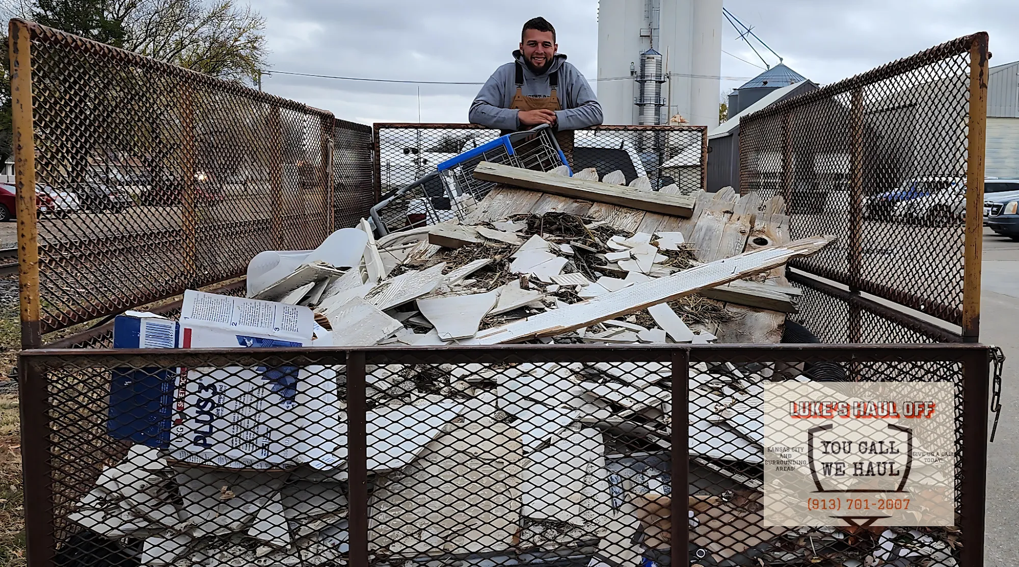 Luke standing in a trailer loaded with construction debris
