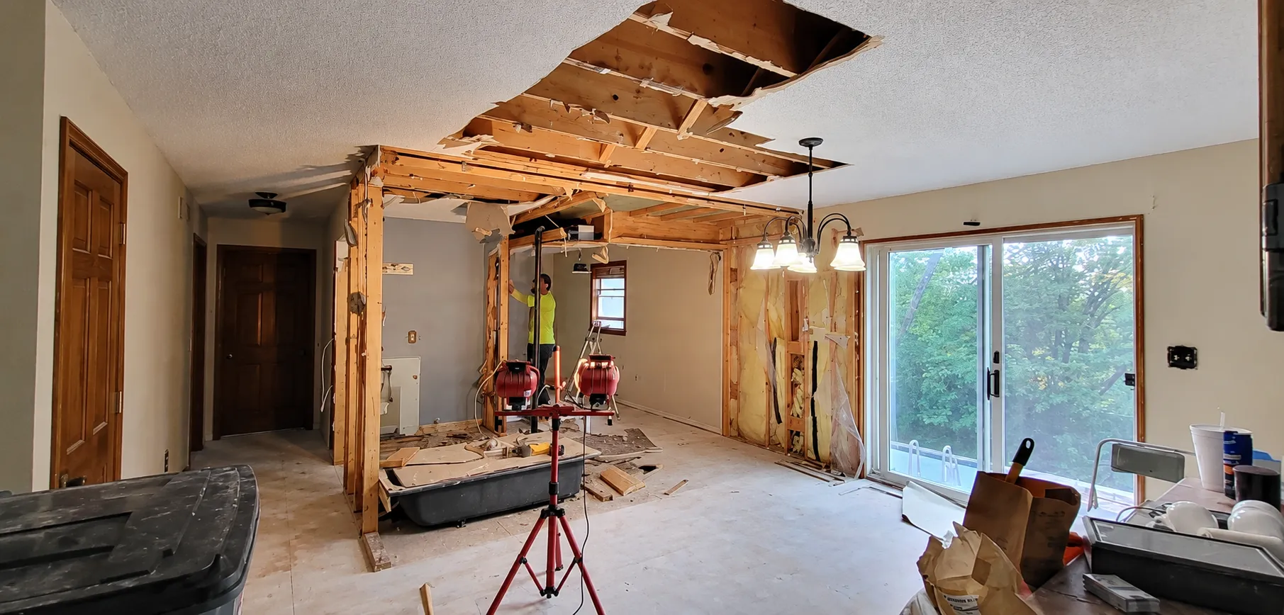 A living room mid-renovation with walls and ceiling opened up